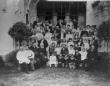Large group portrait of men, women, and children gathered on a terrace during David Sarajishvili’s 25th wedding anniversary celebration in Tbilisi, 1905.