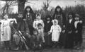 Family group portrait with adults and children posed outdoors, photographed by Vasil Roinashvili.