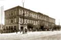 Two-storey 19th-century hotel building on Glovin Avenue in Tbilisi with pedestrians and street activity in front.