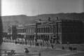 Large neoclassical government building with arched windows and pedestrians in front of it in Tbilisi.