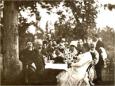 Group of men and women seated outdoors beneath trees, with Peter Chaikovski in the foreground, Kodjori, 1889.