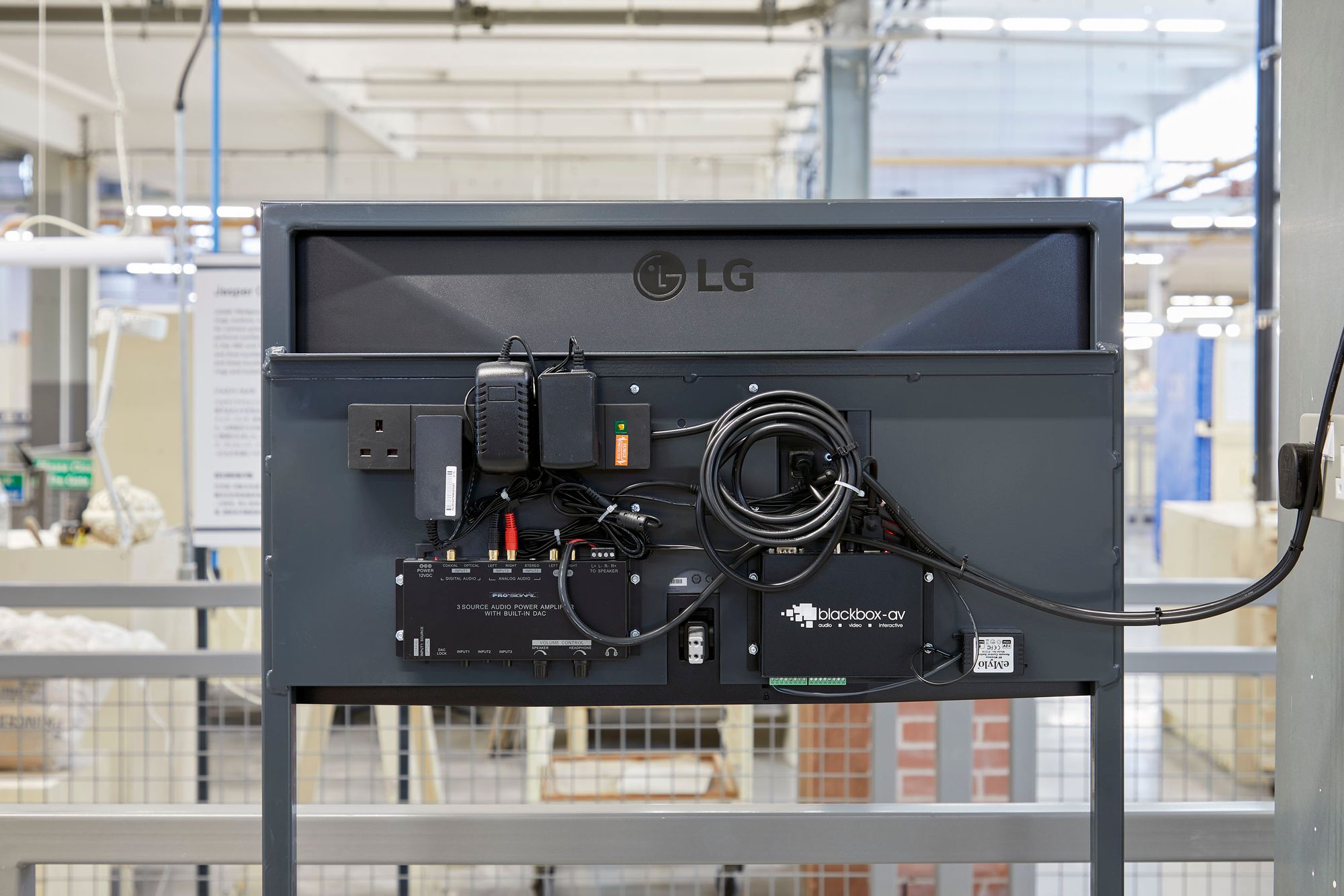 Reverse of monitor stand showing custom mounting plate concealing all media and cabling