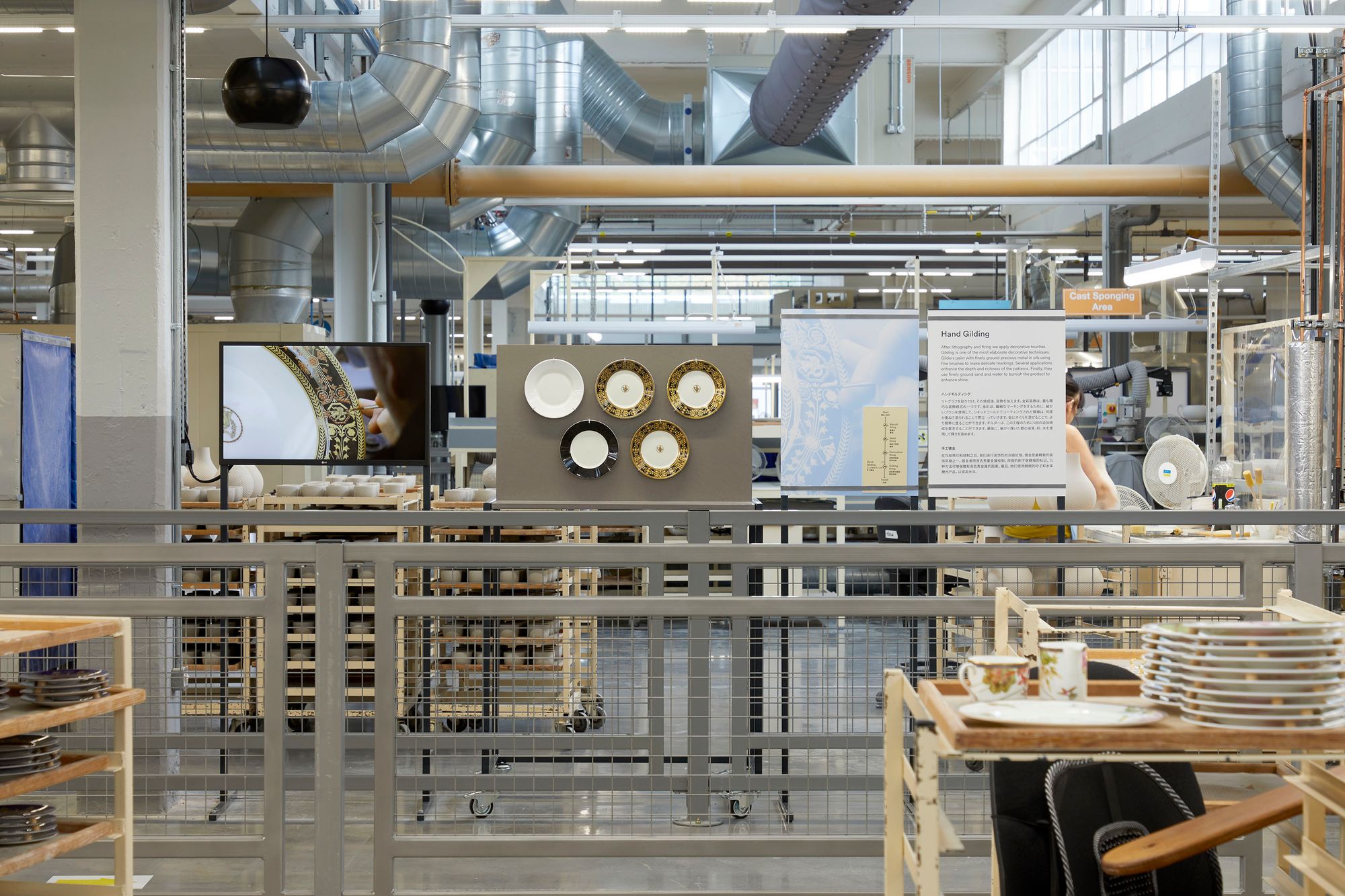 Monitor stand, display furniture and interpretation panels on factory floor showing the gilding process.
