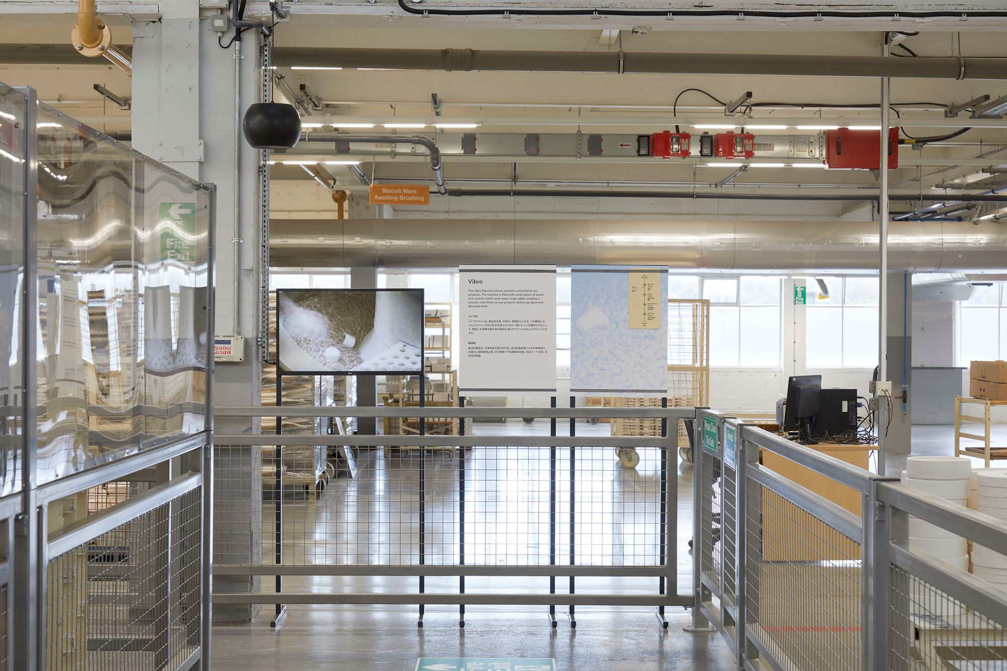 Monitor, pendant speaker and interpretation panels on factory floor showing the Vibro Machine.