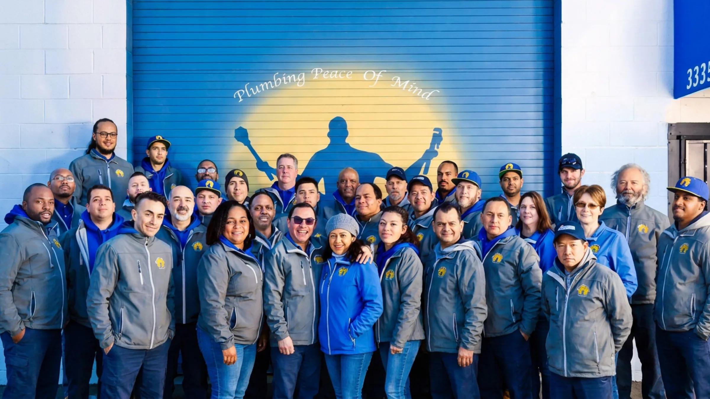 The Albert Nahman team in front of their Plumbing Peace of Mind shop door