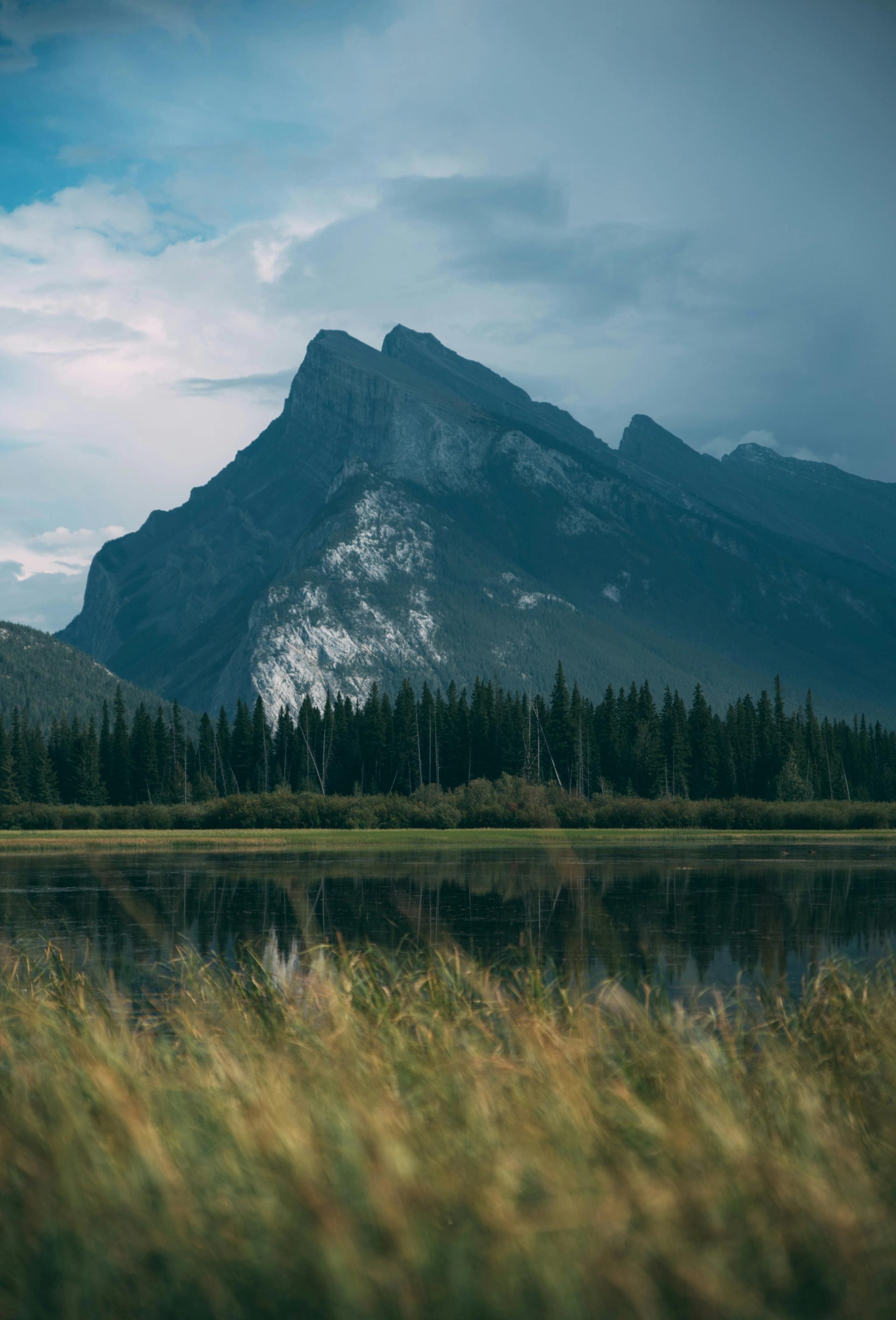 Mountain with grass and lake in the foreground