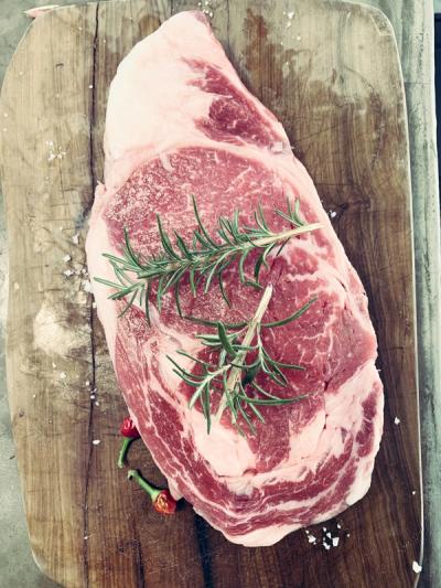 Steak curing on a board with rosemary