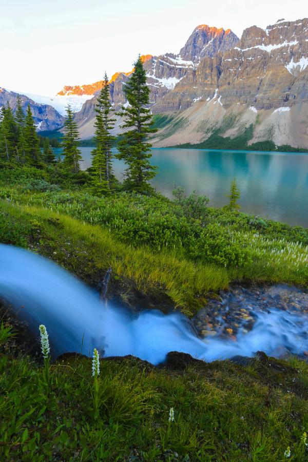 Flowing stream with mountains and glacial lake in the background