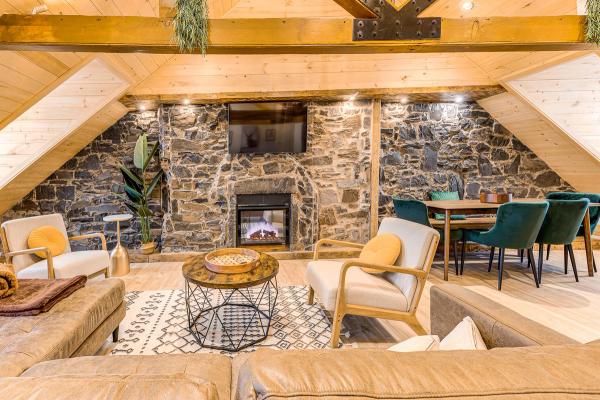 Fireplace with exposed beams and furniture surrounding