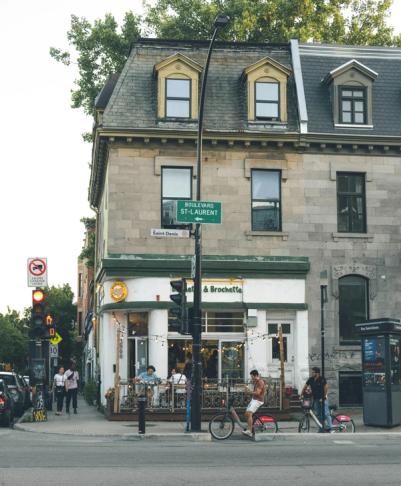People walking and biking by cafe in Montreal, credit malentrossi