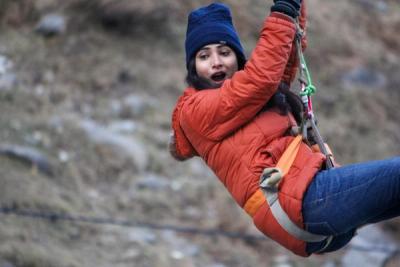 Woman on zipline with slightly scared expression