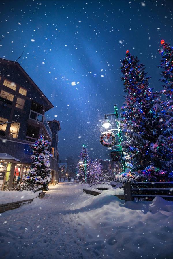 A snowy evening in Whistler Village with lots of Christmas lights