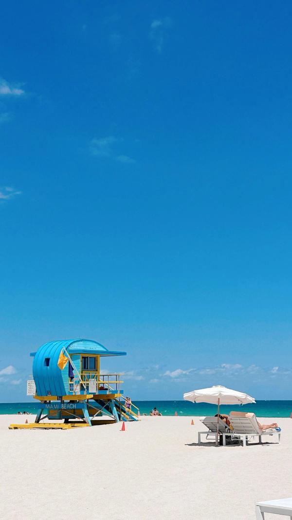 Blue lifeguard tower on white sand beach