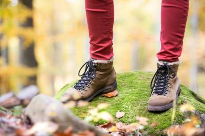 Close up of hiker's boots on a mossy rock