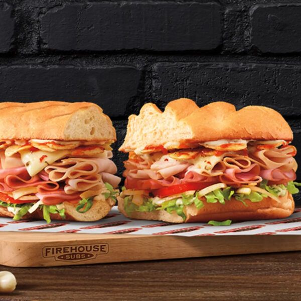Sub on firehouse branded wooden cutting board with black brick background