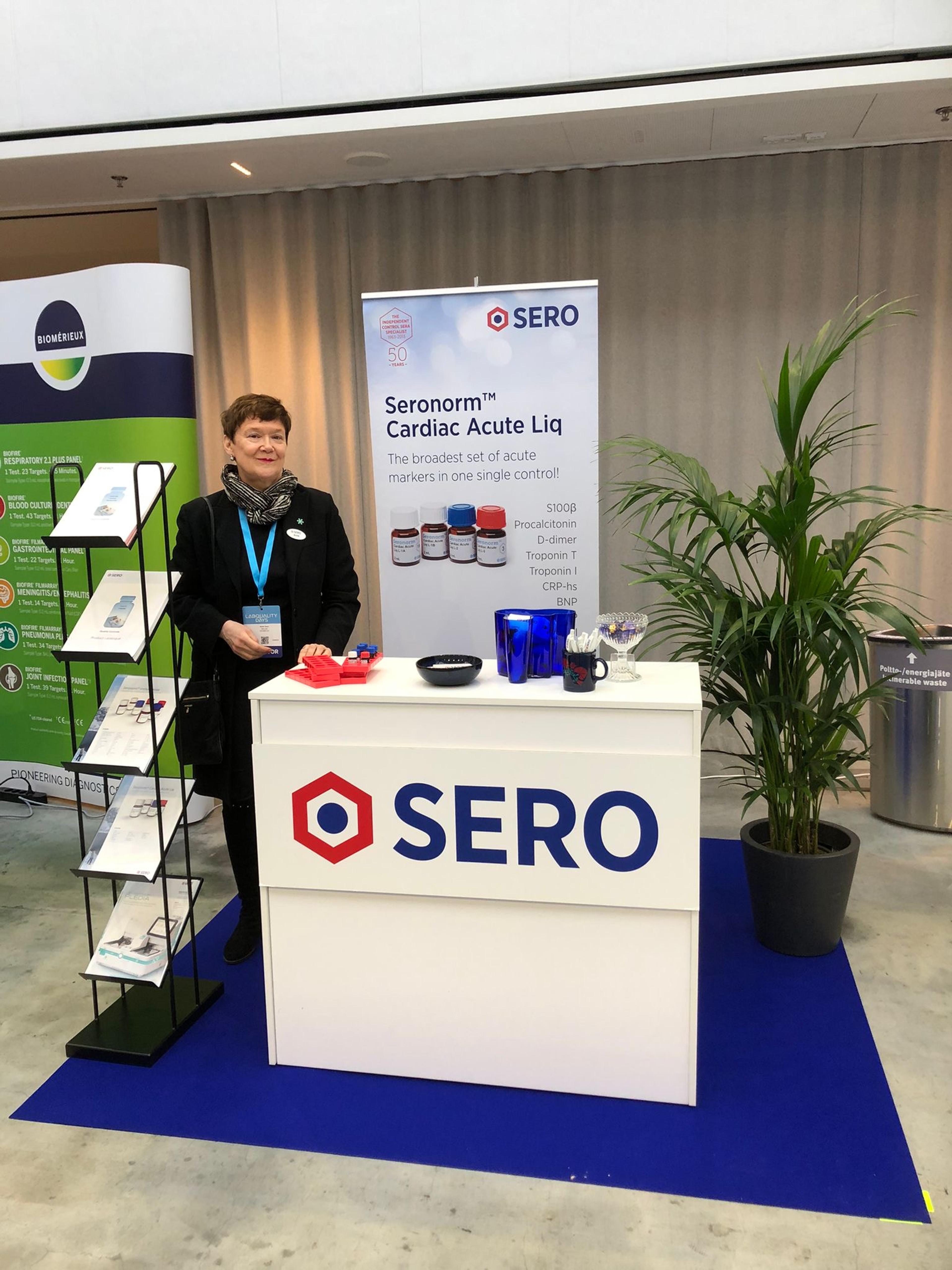 a woman stands in front of a sero sign