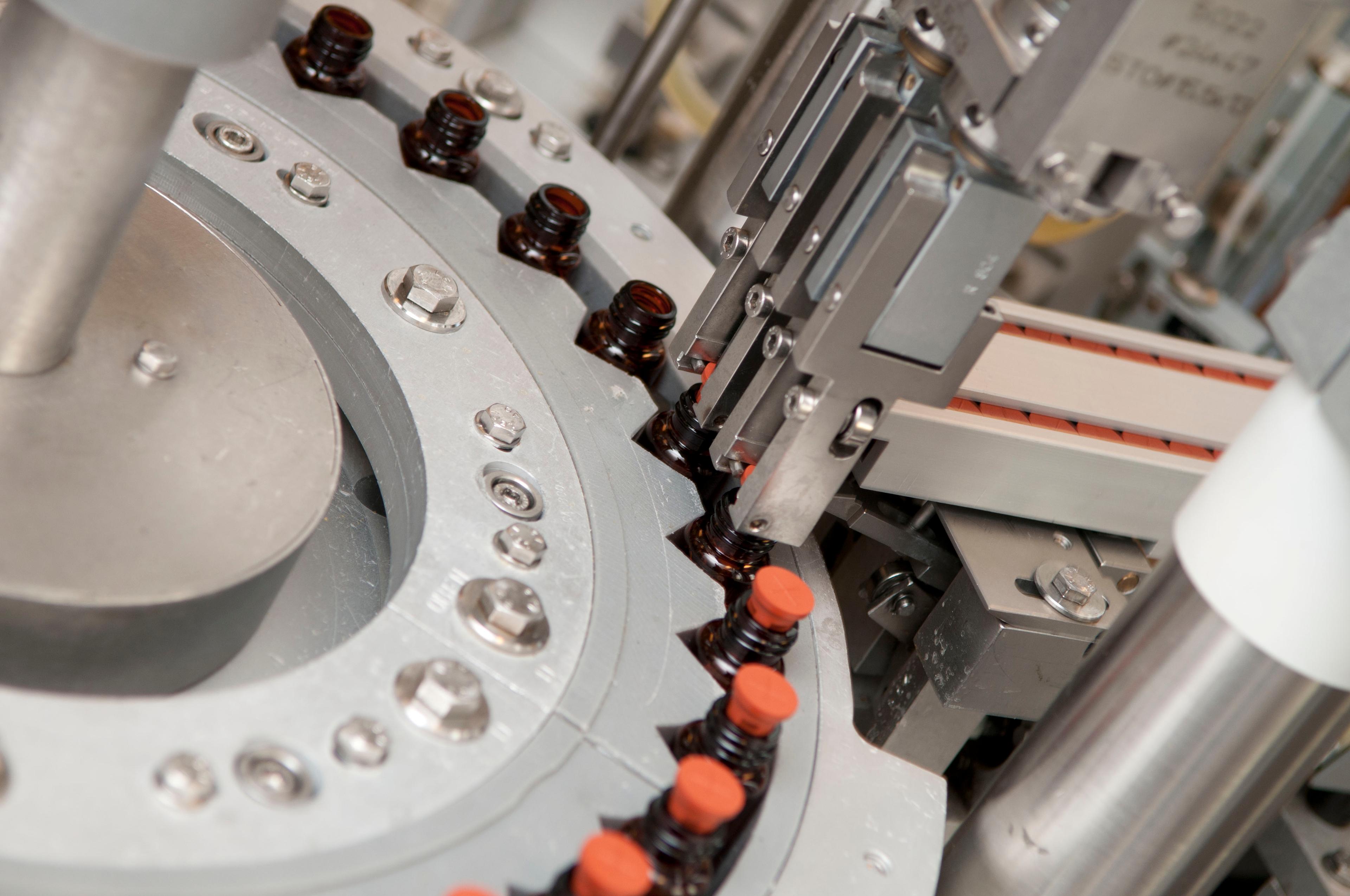 a machine is moving bottles on a conveyor belt in a factory .
