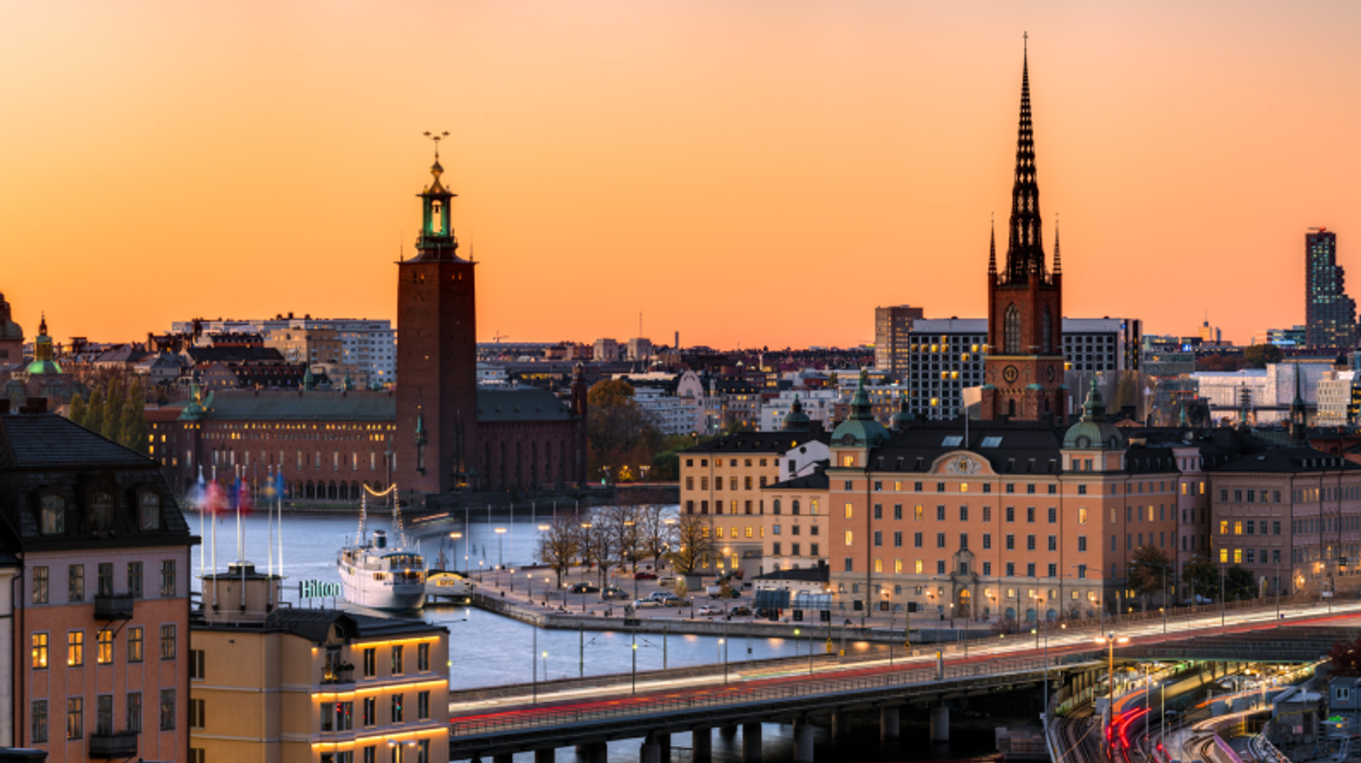 a bridge over a body of water with a clock tower in the background