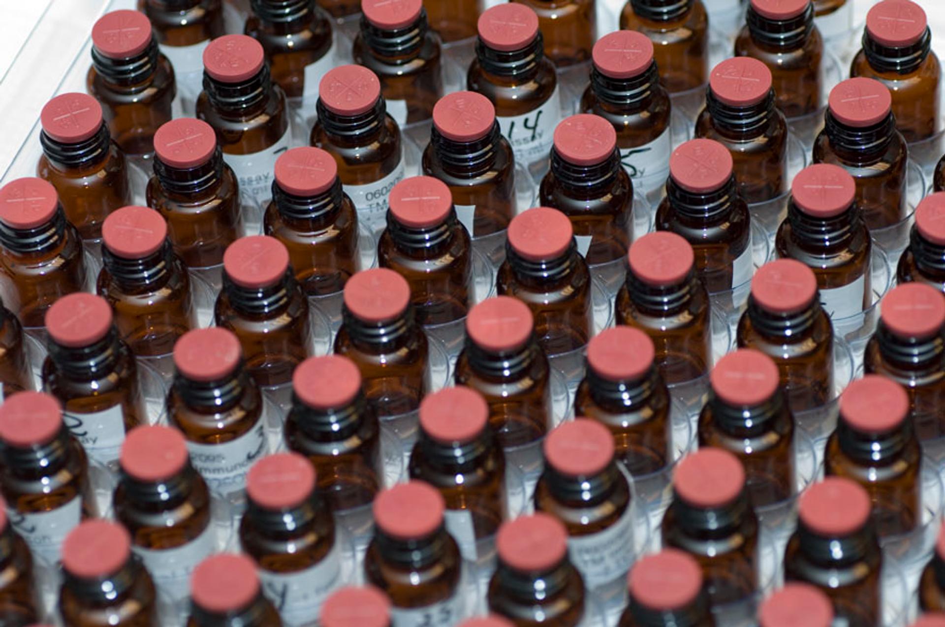 a tray filled with lots of small bottles with red caps .