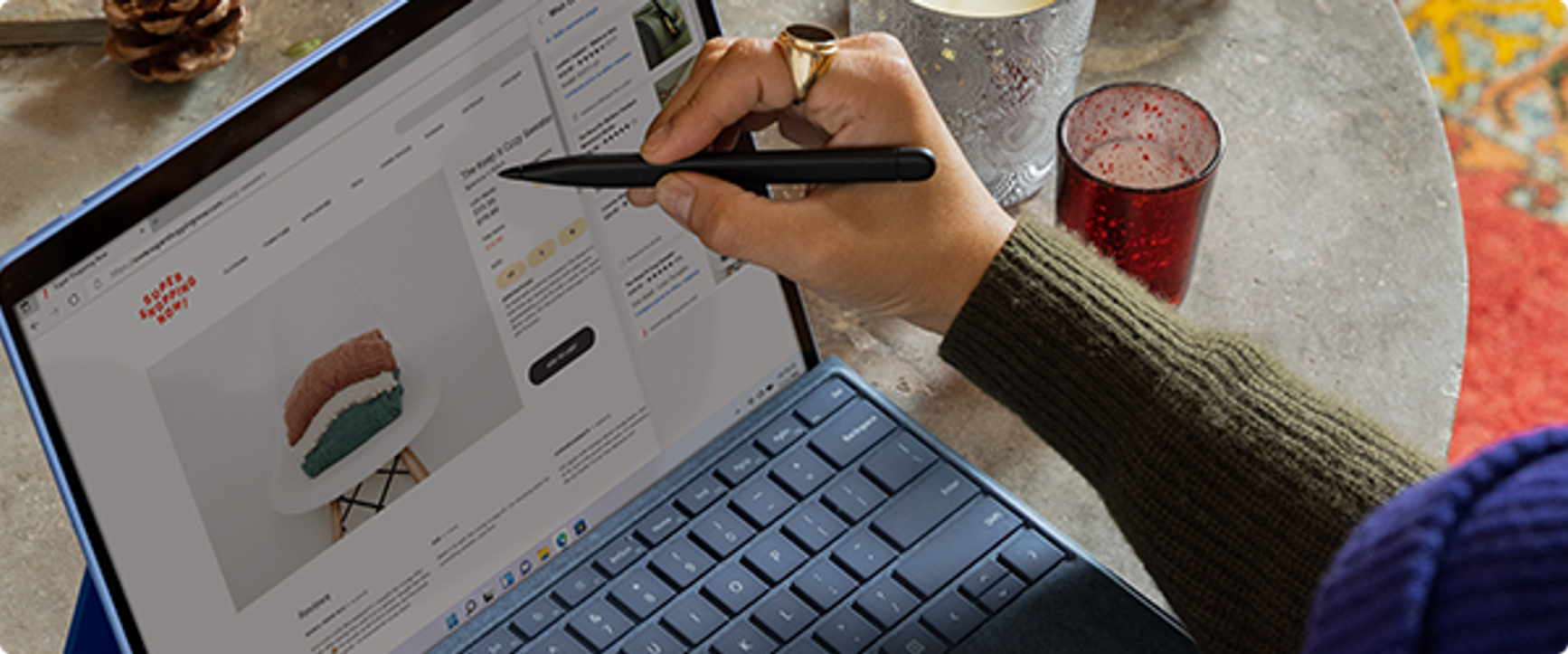 A photo of someone pointing with a stylus to a towel product page open on their laptop.