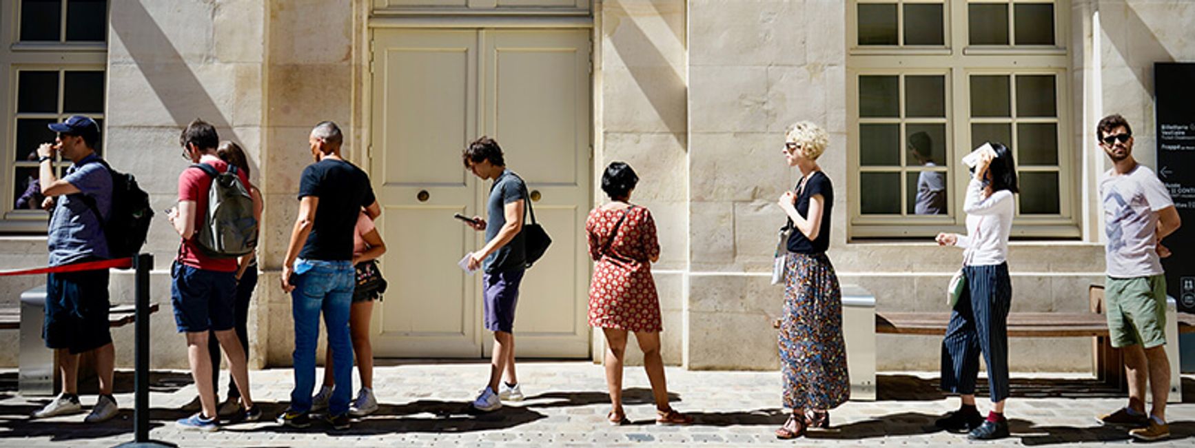 A photo of many people lined up in a queue, waiting for something. 