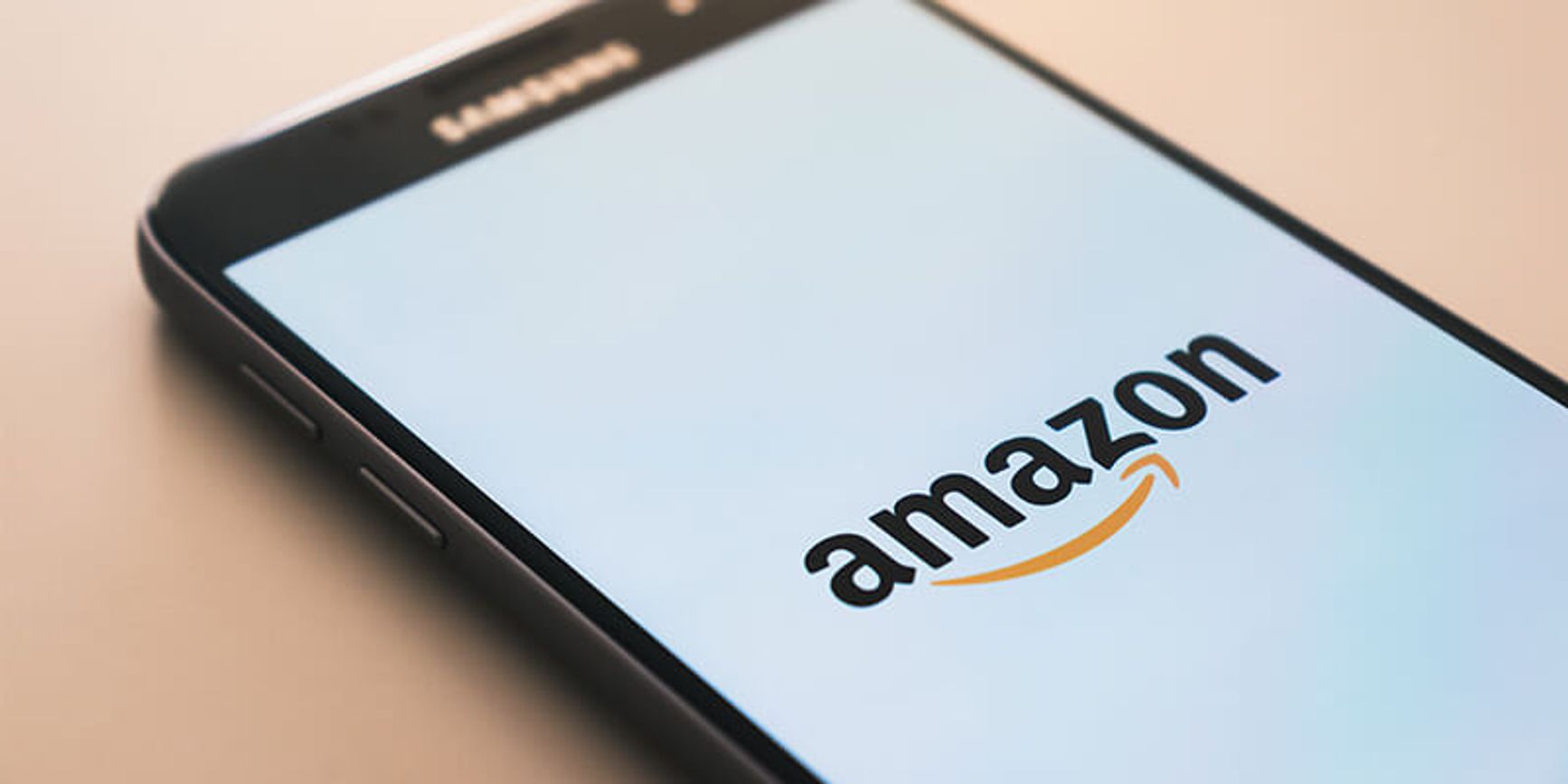 A photo of a phone on a table opening the Amazon app.