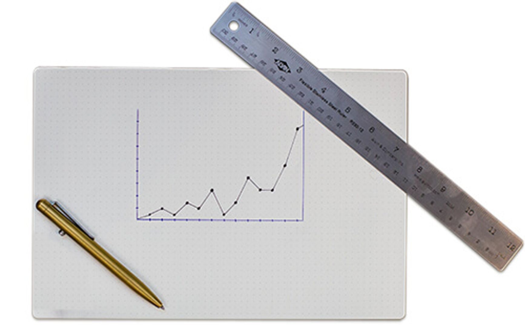 Graph paper with a line graph drawn on it. A ruler and pen rest on the paper.