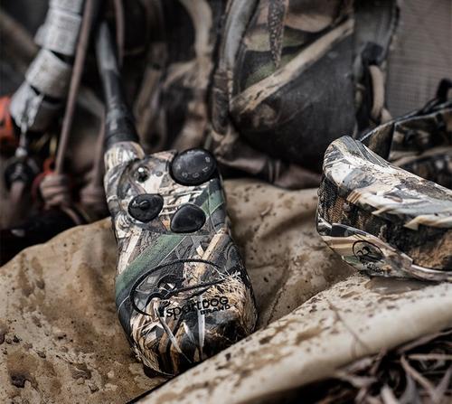 pile of waterfowl gear with focus on camouflaged e-collar system