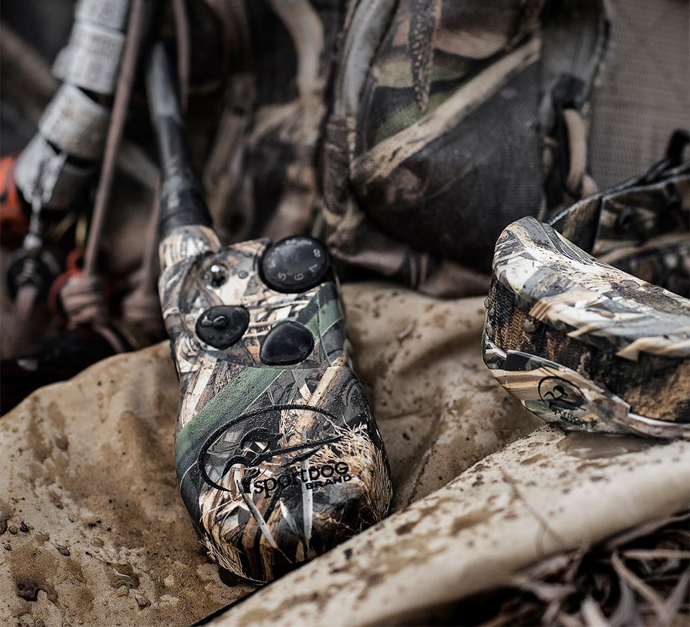pile of waterfowl gear. focus on camouflaged e-collar system