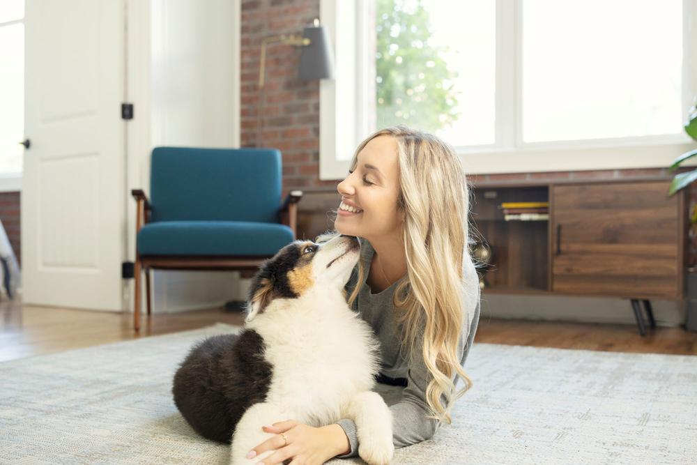 Woman and dog laying on floor