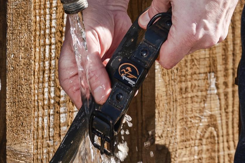 Close up of someone rinsing off a SportDOG rugged utility collar