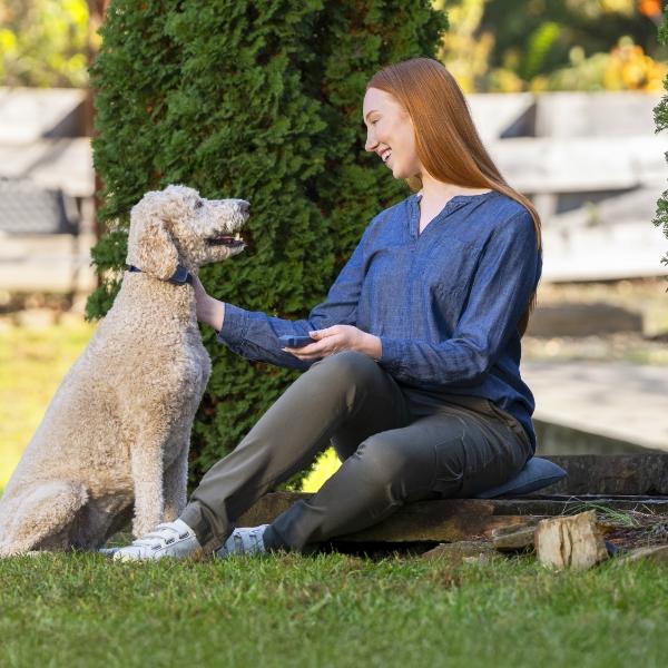 Woman sitting outside and petting dog