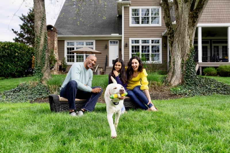 family playing outside with dog