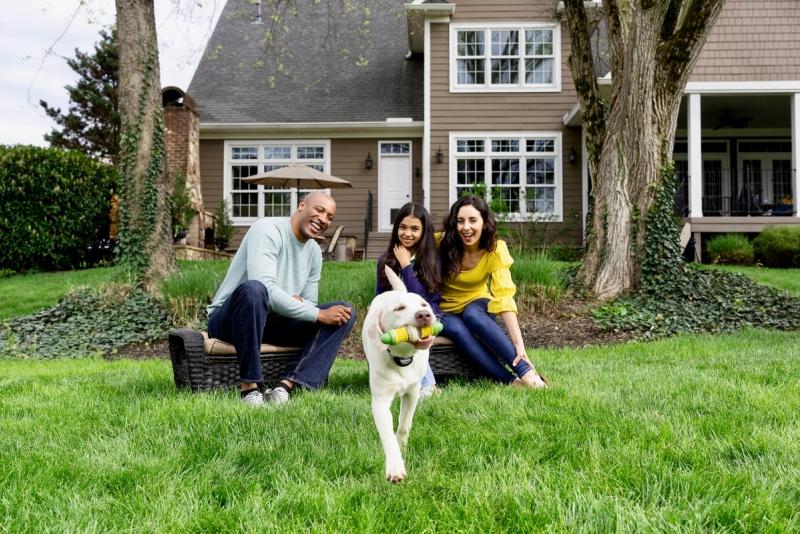 family playing outside with dog