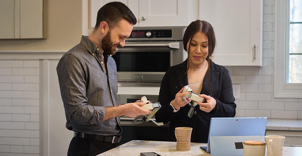 Man and woman opening gps collars in kitchen