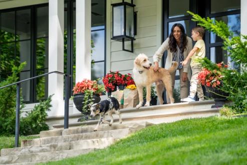 women lets dogs out to play in their yard in their invisible fence 