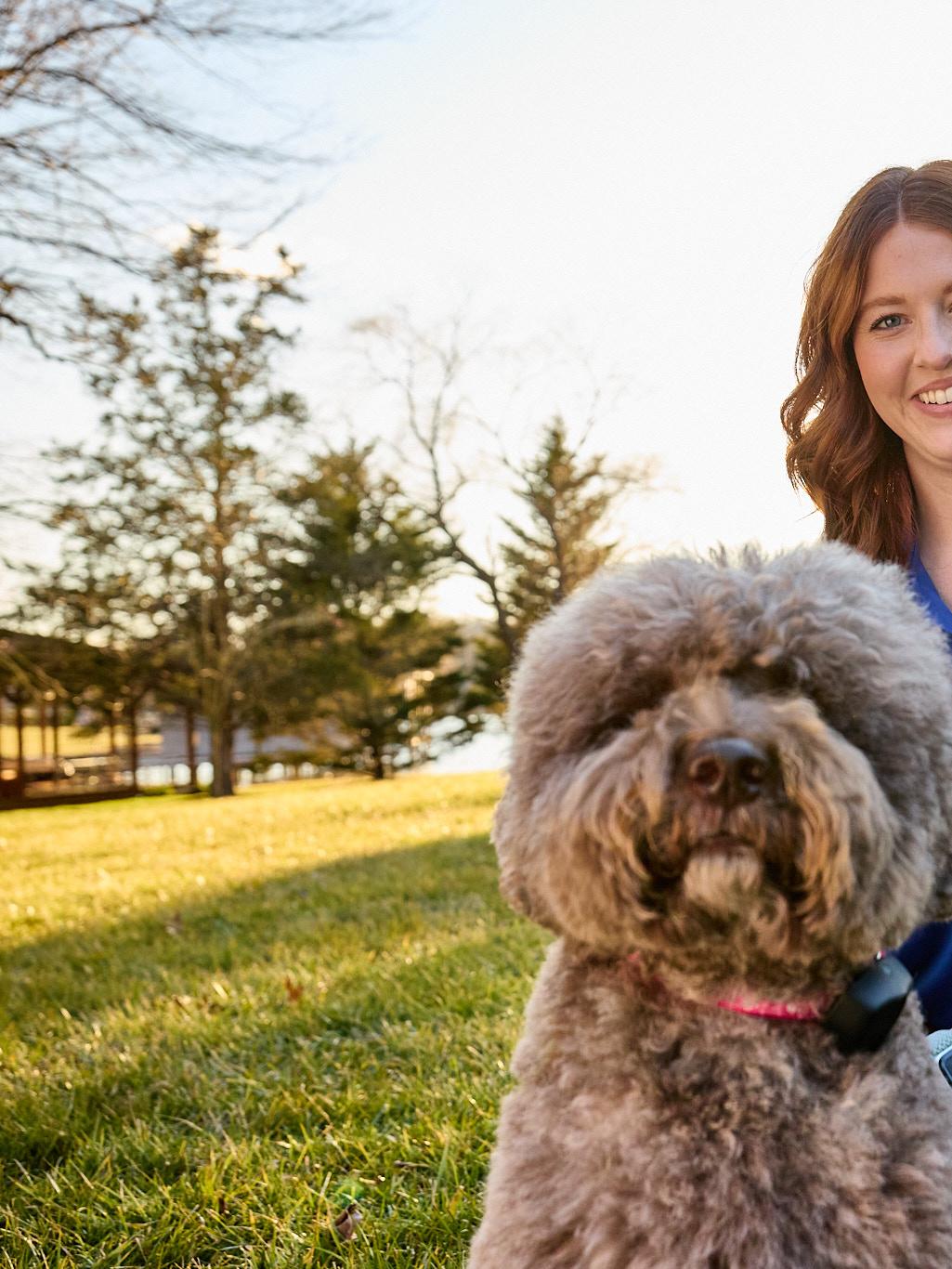 Lagotto Romagnolo dog wearing an invisible fence collar with trainer enjoying the yard