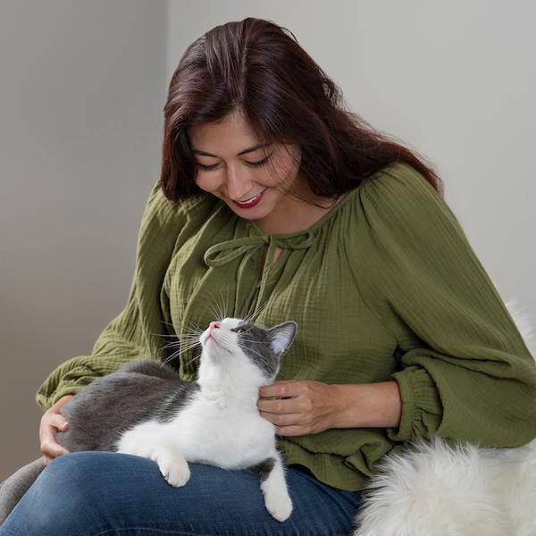 Woman sitting, petting cat