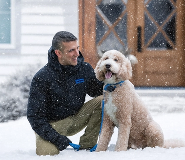 invisible fence trainer and doodle wearing invisible fence collar work on training in the snow