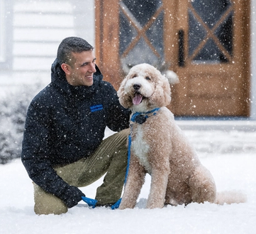 invisible fence trainer working with a doodle in the snow