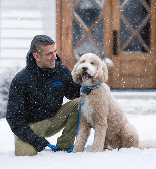 invisible fence trainer works with a doodle in a snowy yard