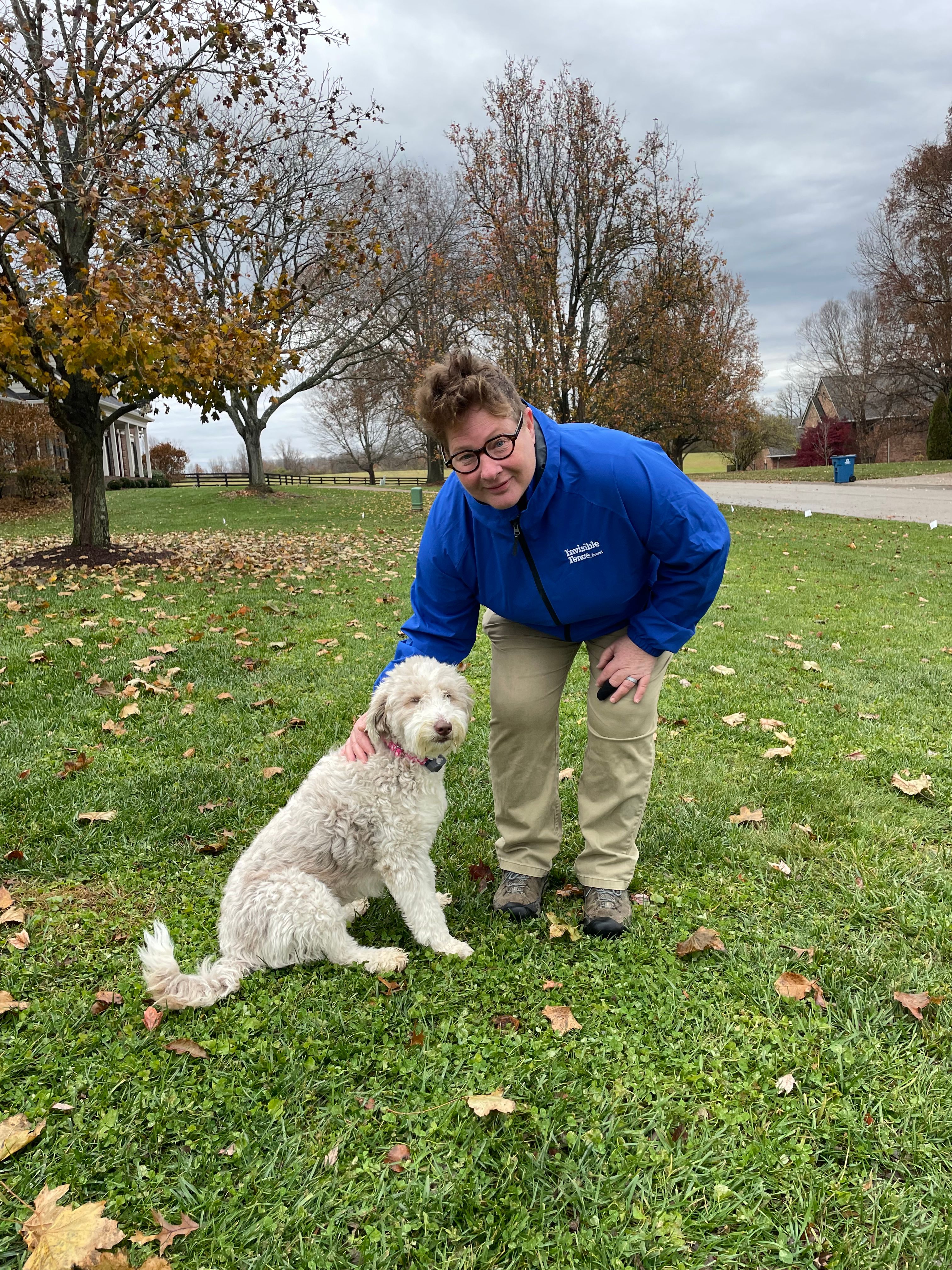 invisible fence trainer works with a poodle in the yard 