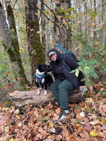 Brie (they/them) and Judy (she/her) take a break on a log while hiking on the Leif Erickson trail in Oregon.