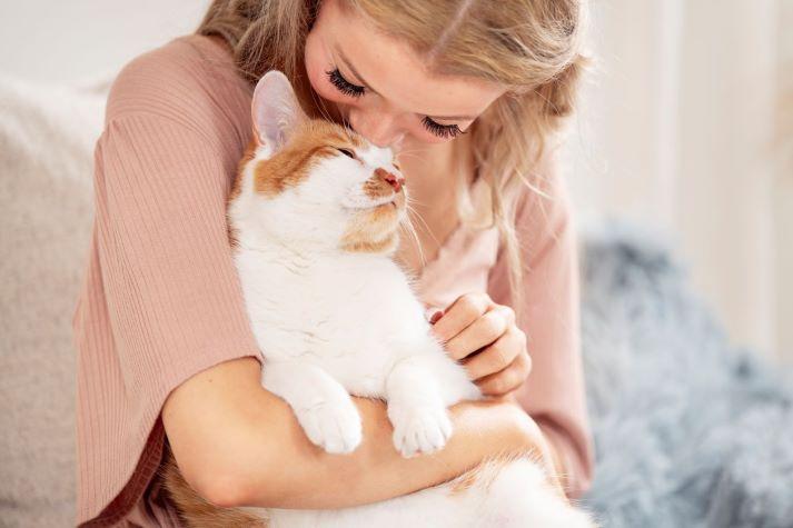 Pet parent cuddling cat