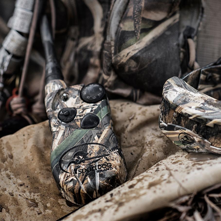 pile of waterfowl gear. focus on camouflaged e-collar system