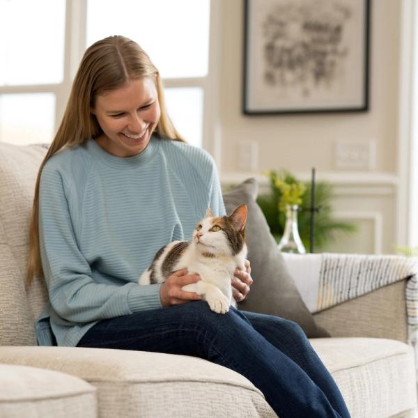 Woman sitting on couch with cat in lap