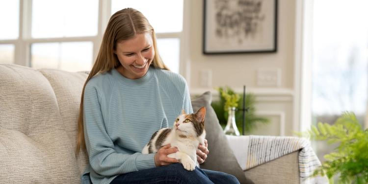 Woman sitting with cat in lap on couch
