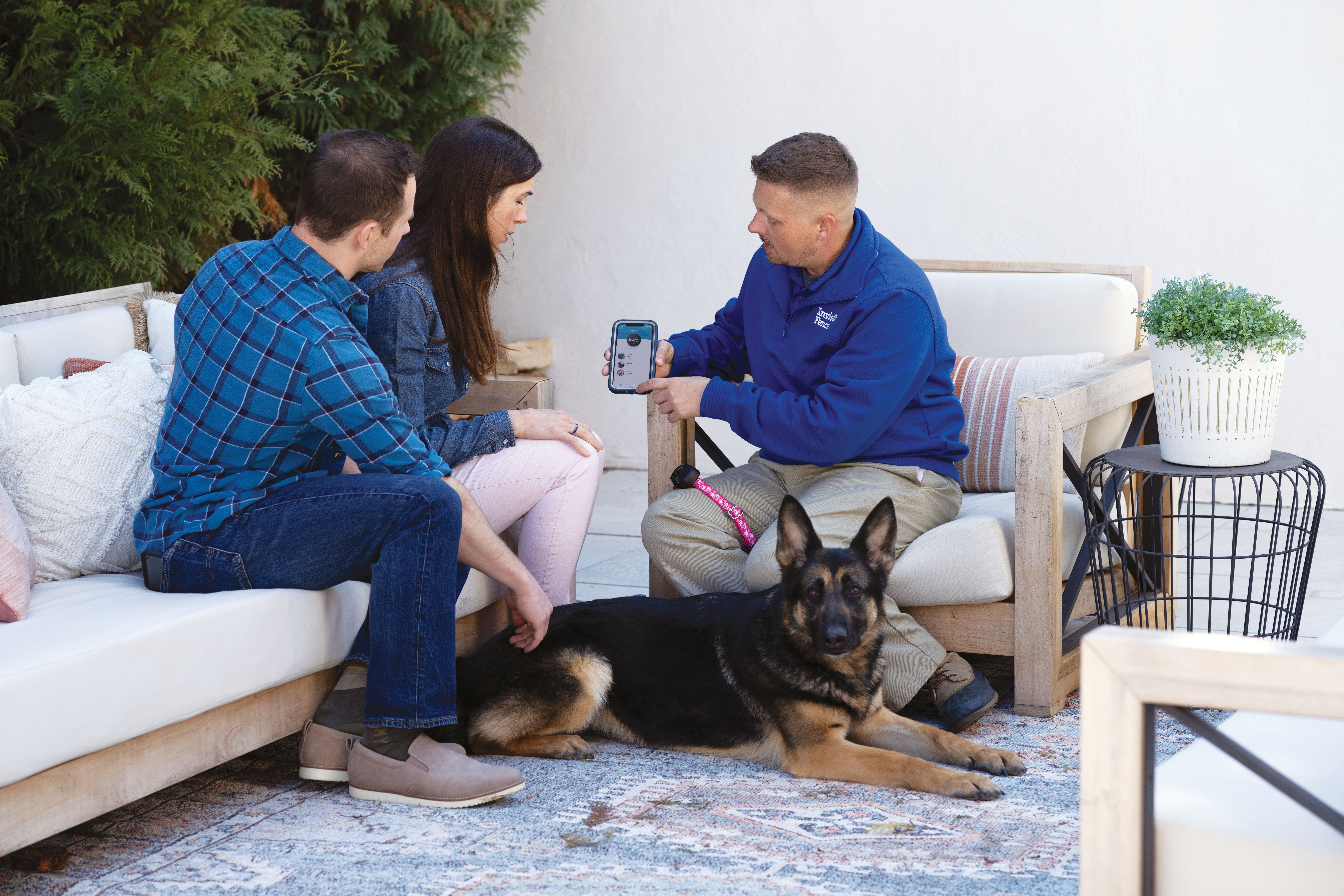 german shepard sits with invisible fence trainer while he programs the invisible fence collar