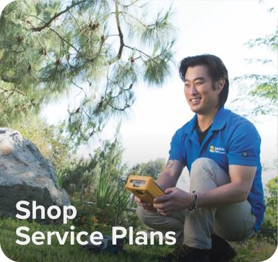Text on screen "Shop Service Plans" with image of an Invisible Fence Brand technician working in a yard