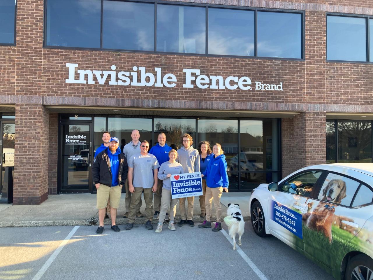 Group of invisible fence of louisville teammates outside of storefront